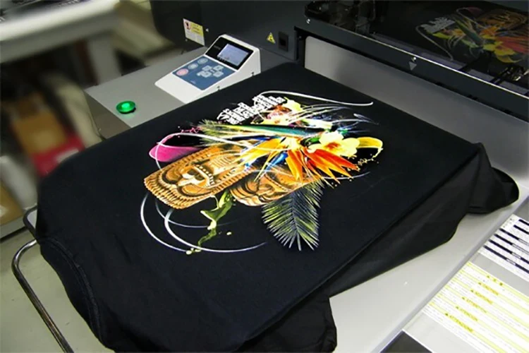 Direct-to-garment printer producing a colourful graphic on a black T-shirt